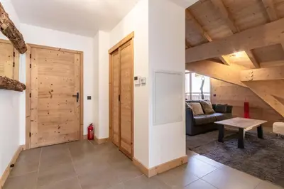 a living room with a wooden door and a couch at Terra Losa 2 - Quiet and modern apartment - City center in Les Houches