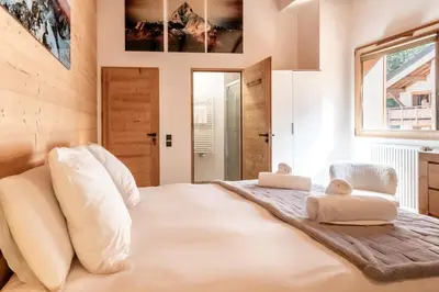a bedroom with a large white bed with two stuffed animals on it at Terra Losa 2 - Quiet and modern apartment - City center in Les Houches