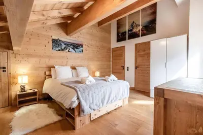 a bedroom with a bed and a wooden wall at Terra Losa 2 - Quiet and modern apartment - City center in Les Houches
