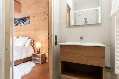 a bathroom with a sink and a bed in a room at Terra Losa 2 - Quiet and modern apartment - City center in Les Houches