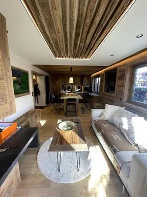 a living room with a couch and a table at Appartement centre megeve in Megève