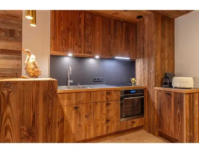 a kitchen with wooden cabinets and a sink at Modern 2 bedroom apartment, close to ski lifts in Megève