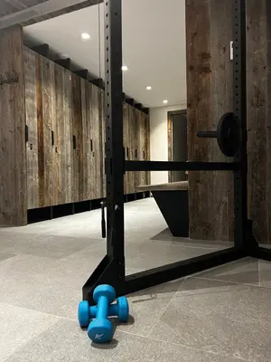 a gym with a mirror and blue dumbbells at Chalet Esquinade 4 bedrooms appartment Megève in Megève