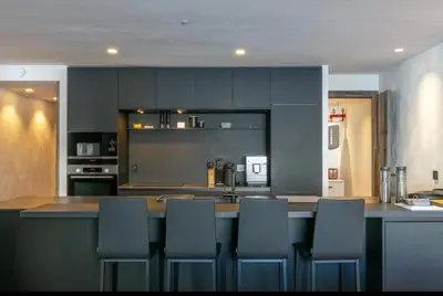 a kitchen with a bar with chairs around it at Chalet Esquinade 4 bedrooms appartment Megève in Megève