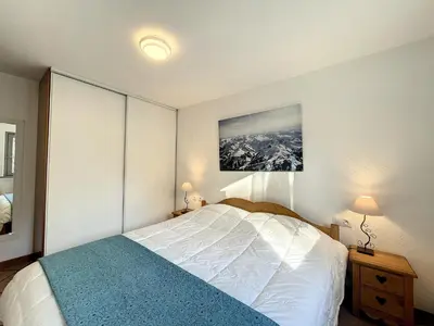 a bedroom with a bed and a picture on the wall at Appartement au centre de Chamonix - 6 pers, parking, confort 3 étoiles - FR-1-507-74 in Chamonix-Mont-Blanc
