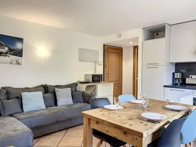 a living room with a couch and a wooden table at Appartement au centre de Chamonix - 6 pers, parking, confort 3 étoiles - FR-1-507-74 in Chamonix-Mont-Blanc