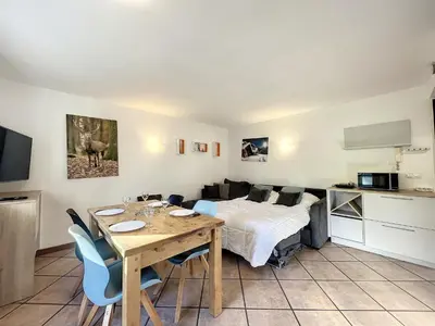 a bedroom with a bed and a table with chairs at Appartement au centre de Chamonix - 6 pers, parking, confort 3 étoiles - FR-1-507-74 in Chamonix-Mont-Blanc