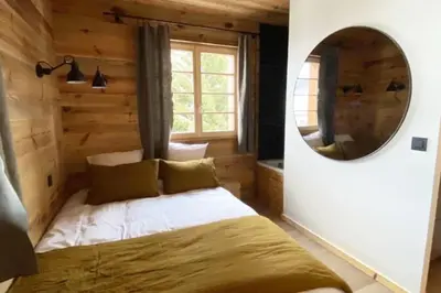a bedroom with a bed and a mirror at Megeve cosy appartement Bianca centre in Megève