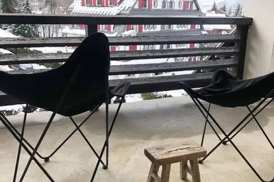 two black chairs and a stool on a balcony at Megeve cosy appartement Bianca centre in Megève