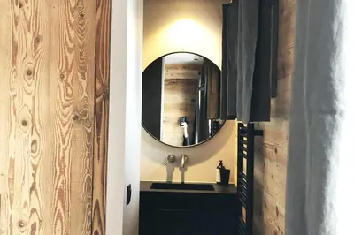 a hallway with a mirror and a black dresser at Megeve cosy appartement Bianca centre in Megève