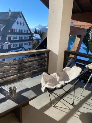a chair sitting on a balcony with a table at Megeve cosy appartement Bianca centre in Megève