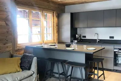 a kitchen with a counter and stools in a room at Megeve cosy appartement Bianca centre in Megève