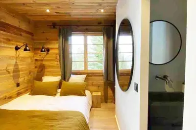 a bedroom with a bed and a mirror and a sink at Megeve cosy appartement Bianca centre in Megève