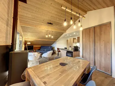 a kitchen and dining room with a wooden table and chairs at Appartement neuf avec vue Mont Blanc, parking et wifi à Combloux - FR-1-560-113 in Combloux