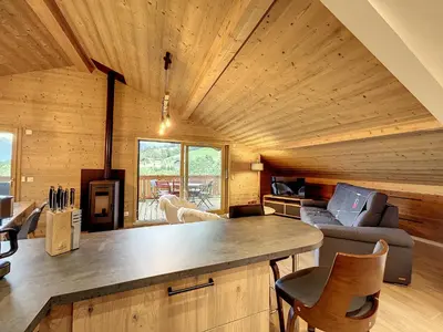 a kitchen and living room in a log cabin at Appartement neuf avec vue Mont Blanc, parking et wifi à Combloux - FR-1-560-113 in Combloux
