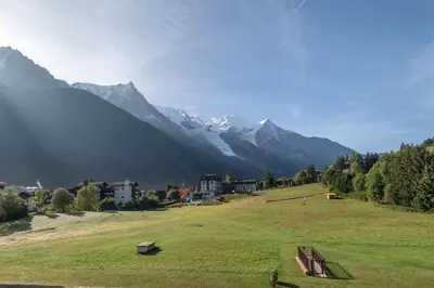 a grassy field with a mountain in the background at SmartStay Mummery - Chamonix in Chamonix-Mont-Blanc