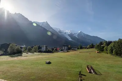 a person standing in a field with mountains in the background at SmartStay Mummery - Chamonix in Chamonix-Mont-Blanc