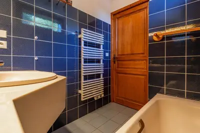 a bathroom with blue tiles and a tub and a sink at SmartStay Mummery - Chamonix in Chamonix-Mont-Blanc