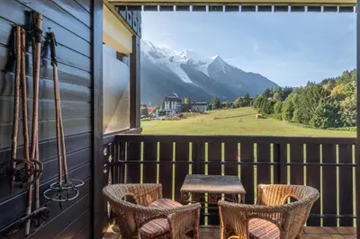 a balcony with chairs and a table and a view at SmartStay Mummery - Chamonix in Chamonix-Mont-Blanc