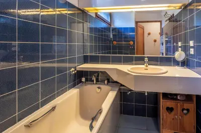 a blue tiled bathroom with a sink and a tub at SmartStay Mummery - Chamonix in Chamonix-Mont-Blanc