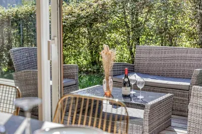 a patio table with a bottle of wine and two glasses at chalet Relax située a 25km de Chamonix in Saint-Gervais-les-Bains