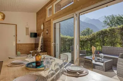 a room with a table and chairs and a large window at chalet Relax située a 25km de Chamonix in Saint-Gervais-les-Bains