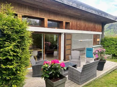 a house with a deck with chairs and a table at chalet Relax située a 25km de Chamonix in Saint-Gervais-les-Bains