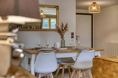 a kitchen with a table with chairs and a mirror at Appartement «Chez Paulette»situé à 25Km chamonix  in Saint-Gervais-les-Bains