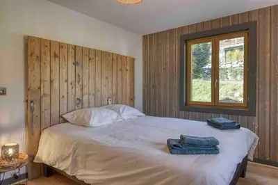 a bedroom with a bed with two towels on it at Appartement «Chez Paulette»situé à 25Km chamonix  in Saint-Gervais-les-Bains