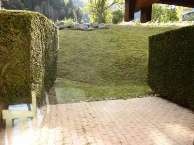 a bench sitting between two hedge hedges in a park at Résidence Les Trolles - Trolles 5A MAE-7374 in Les Contamines-Montjoie