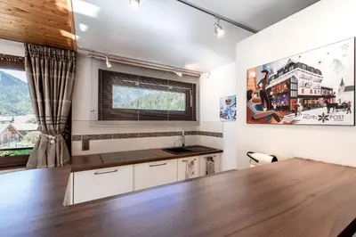 a kitchen with a wooden table and a large window at Les Marmottes - Renovated and cozy apart - View of the mountains in Les Houches