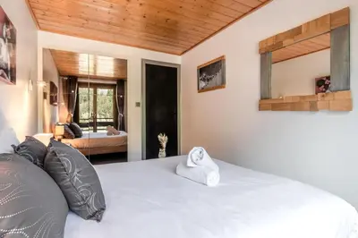 a bedroom with a large white bed with a mirror at Les Marmottes - Renovated and cozy apart - View of the mountains in Les Houches