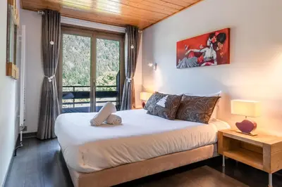a bedroom with a bed and a window at Les Marmottes - Renovated and cozy apart - View of the mountains in Les Houches