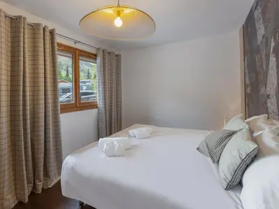 a bedroom with a white bed and a window at Appartement moderne 3 chambres à Megève avec garage - FR-1-569-131 in Megève