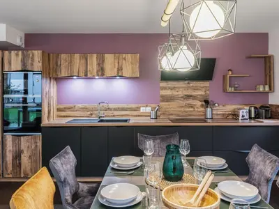 a dining room with a table and chairs and a kitchen at Appartement moderne 3 chambres à Megève avec garage - FR-1-569-131 in Megève