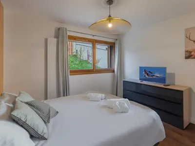 a bedroom with a white bed and a window at Appartement moderne 3 chambres à Megève avec garage - FR-1-569-131 in Megève