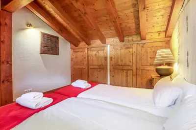 a bedroom with a bed in a room with wooden walls at Amethyste - 2 Bedrooms & Free Parking - By Cozee Rentals in Les Houches