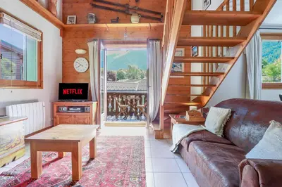 a living room with a couch and a stair case at Amethyste - 2 Bedrooms & Free Parking - By Cozee Rentals in Les Houches