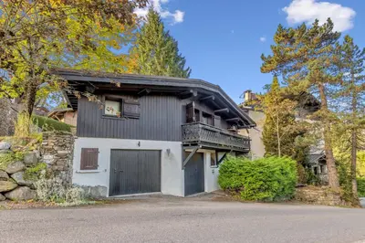 a house with a garage and a balcony at Le Chalet Vigas - Welkeys in Megève