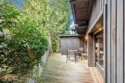 a wooden porch of a house with a table and chairs at Le Chalet Vigas - Welkeys in Megève