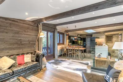 a living room with a couch and a table at Le Chalet Vigas - Welkeys in Megève
