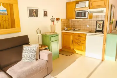 a living room with a couch and a kitchen at Family Apartment Mont Blanc View in Chamonix-Mont-Blanc