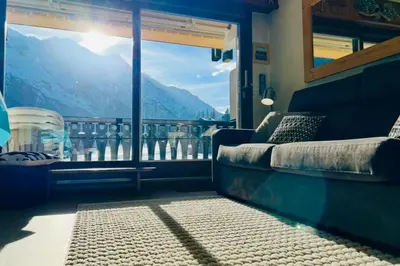 a room with a couch and a window with a view at Family Apartment Mont Blanc View in Chamonix-Mont-Blanc