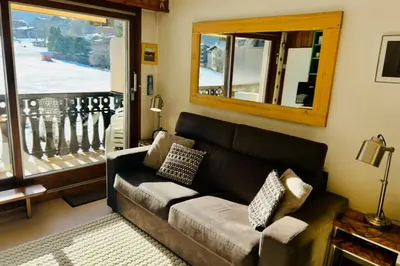 a living room with a couch and a window at Family Apartment Mont Blanc View in Chamonix-Mont-Blanc