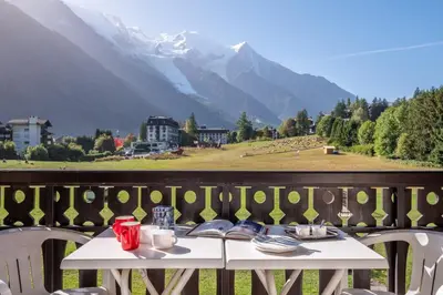 a table on a balcony with a view of a mountain at Family Apartment Mont Blanc View in Chamonix-Mont-Blanc