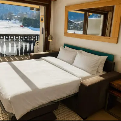 a large bed in a room with a window at Family Apartment Mont Blanc View in Chamonix-Mont-Blanc