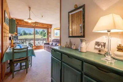 a kitchen with a table and a living room at Family Apartment Mont Blanc View in Chamonix-Mont-Blanc