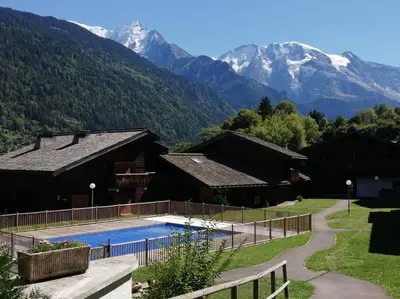 a large building with a pool in front of it at Studio cosy au pied des pistes avec piscine in Saint-Gervais-les-Bains