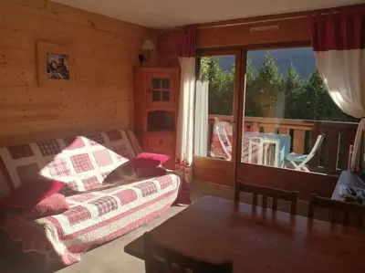 a room with a table and chairs and a balcony at Studio cosy au pied des pistes avec piscine in Saint-Gervais-les-Bains