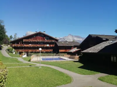 a church with a steeple on top of a building at Studio cosy au pied des pistes avec piscine in Saint-Gervais-les-Bains